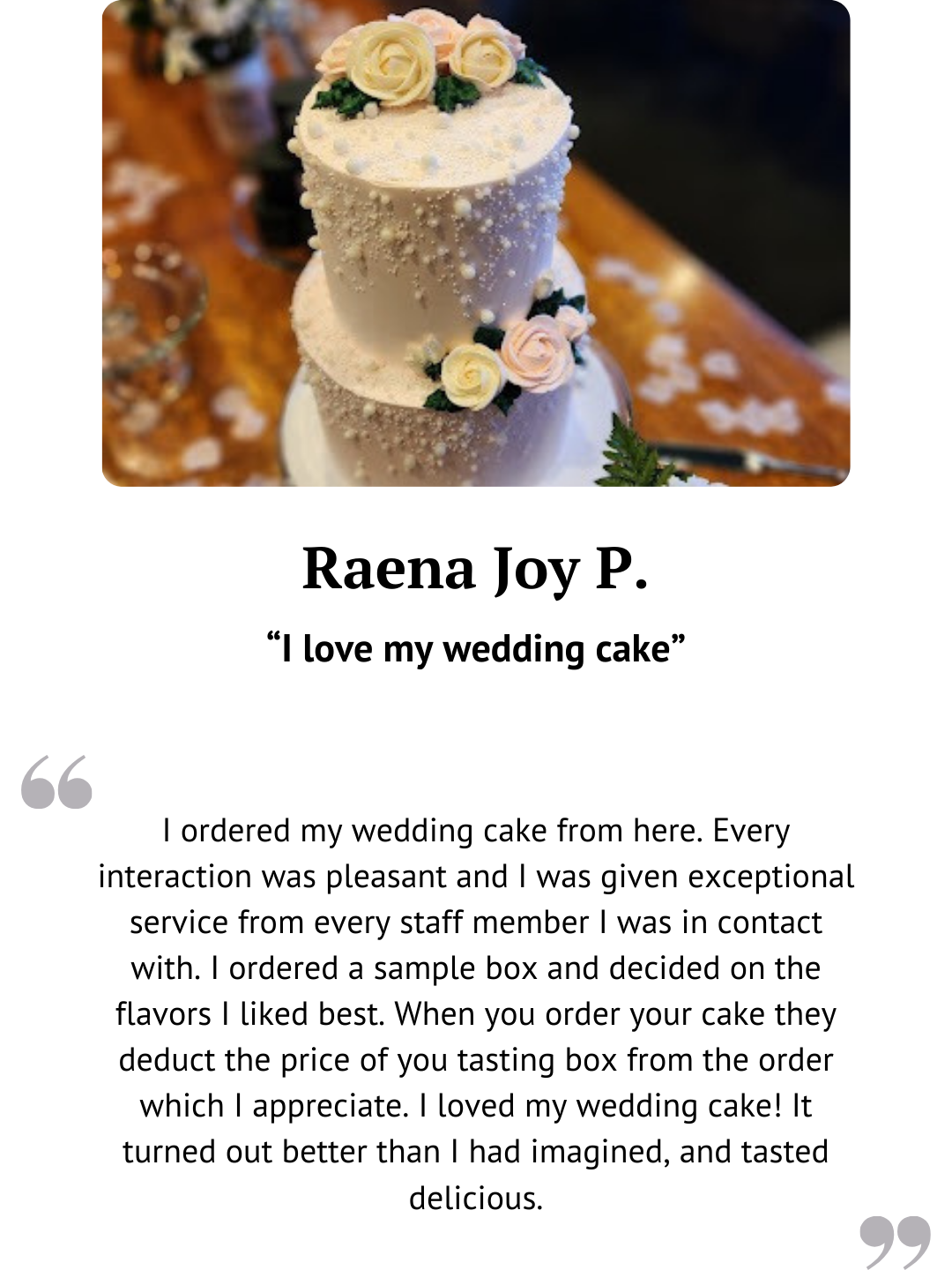 Two-tier white wedding cake with sugar pearls and blush roses.