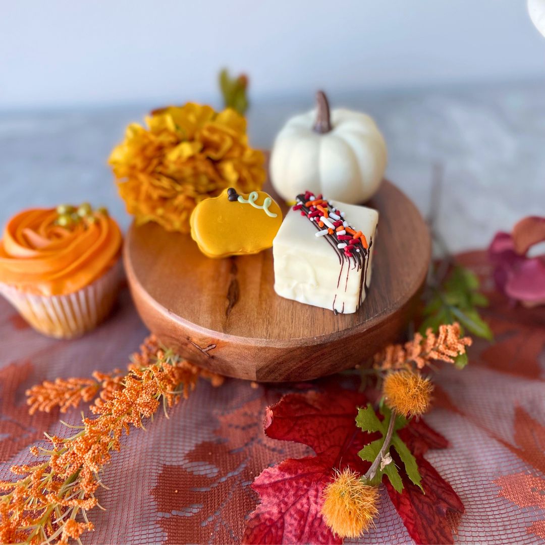 Autumn-themed treats square cake with a chocolate drizzle and sprinkles, and a miniature pumpkin-shaped cake.