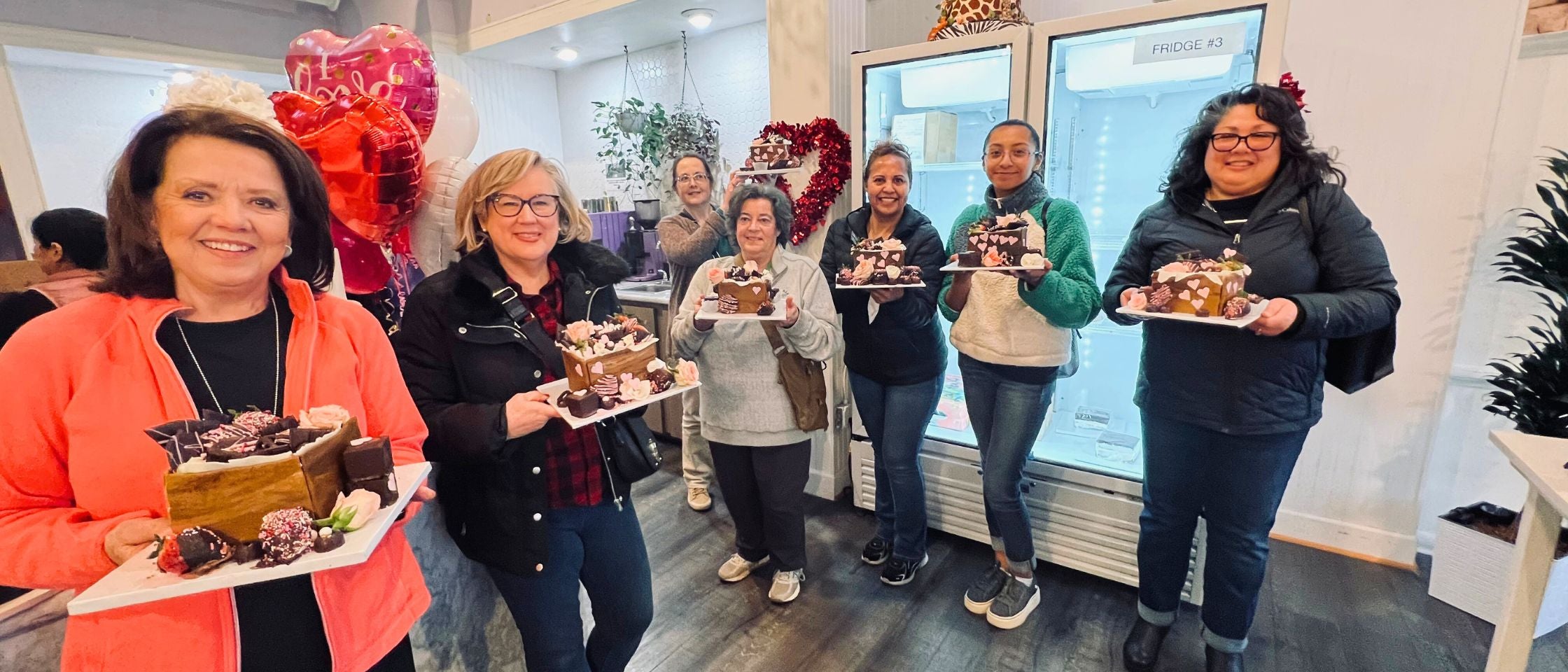 a group of woman holding a cake