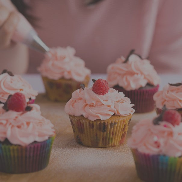 Cupcakes with pink frosting and raspberries