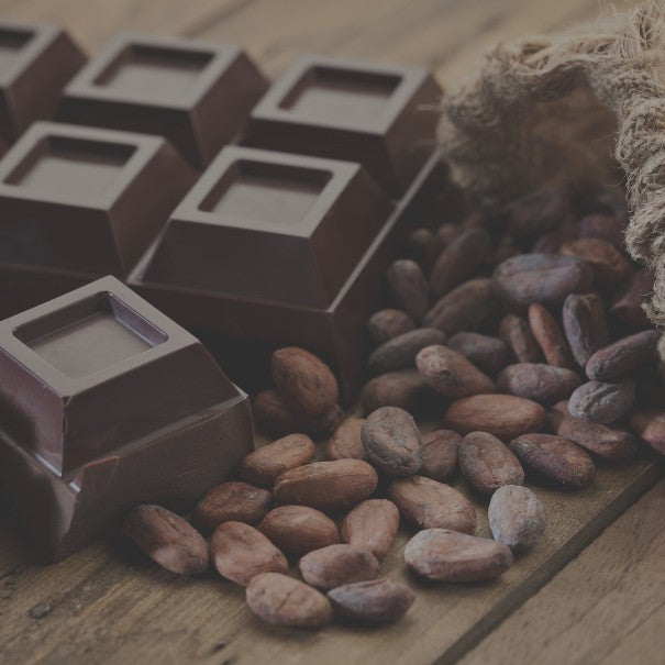 Chocolate bars and cocoa beans on a wooden surface