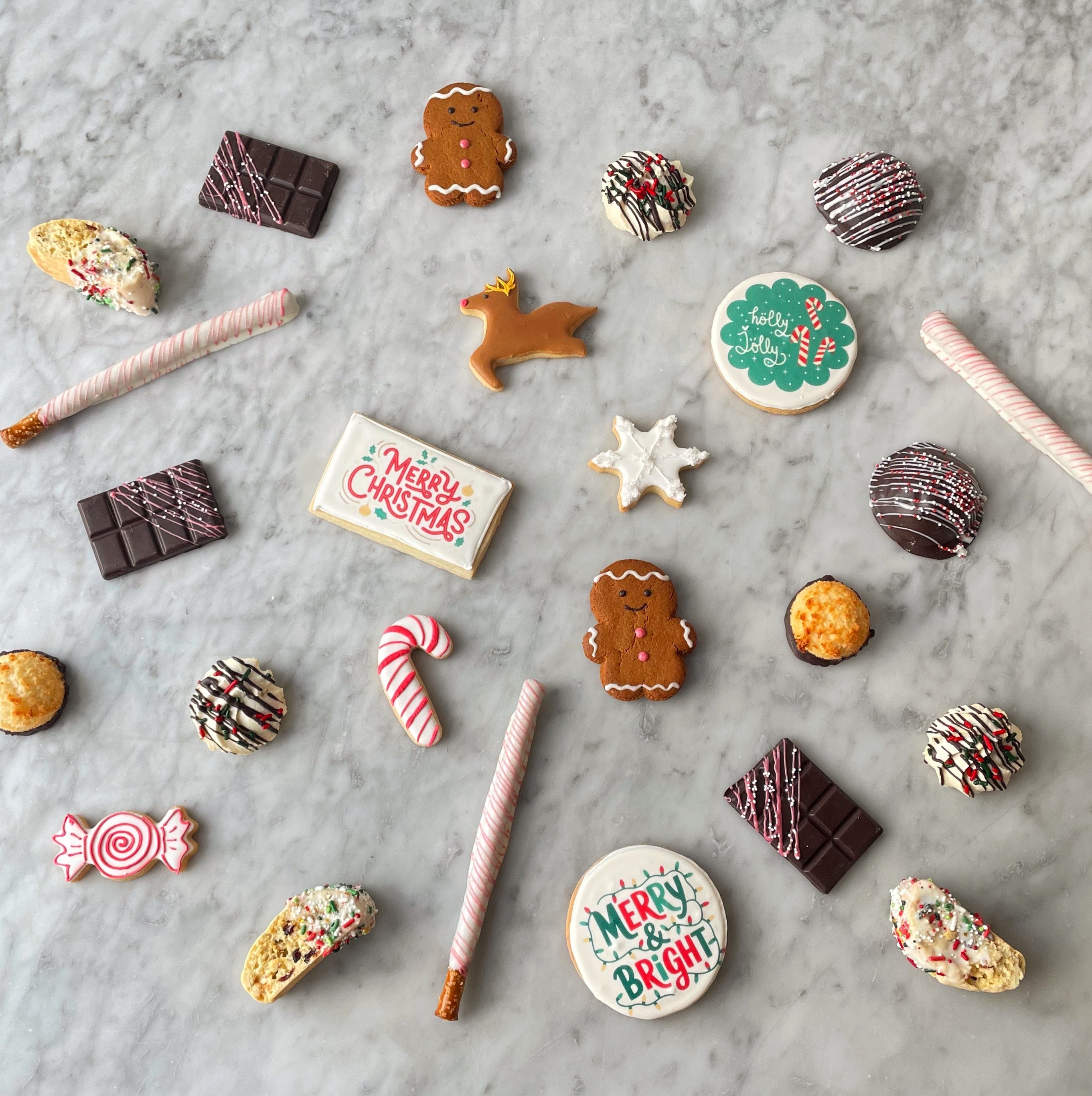 Assorted Christmas cookies and candies arranged on a marble surface