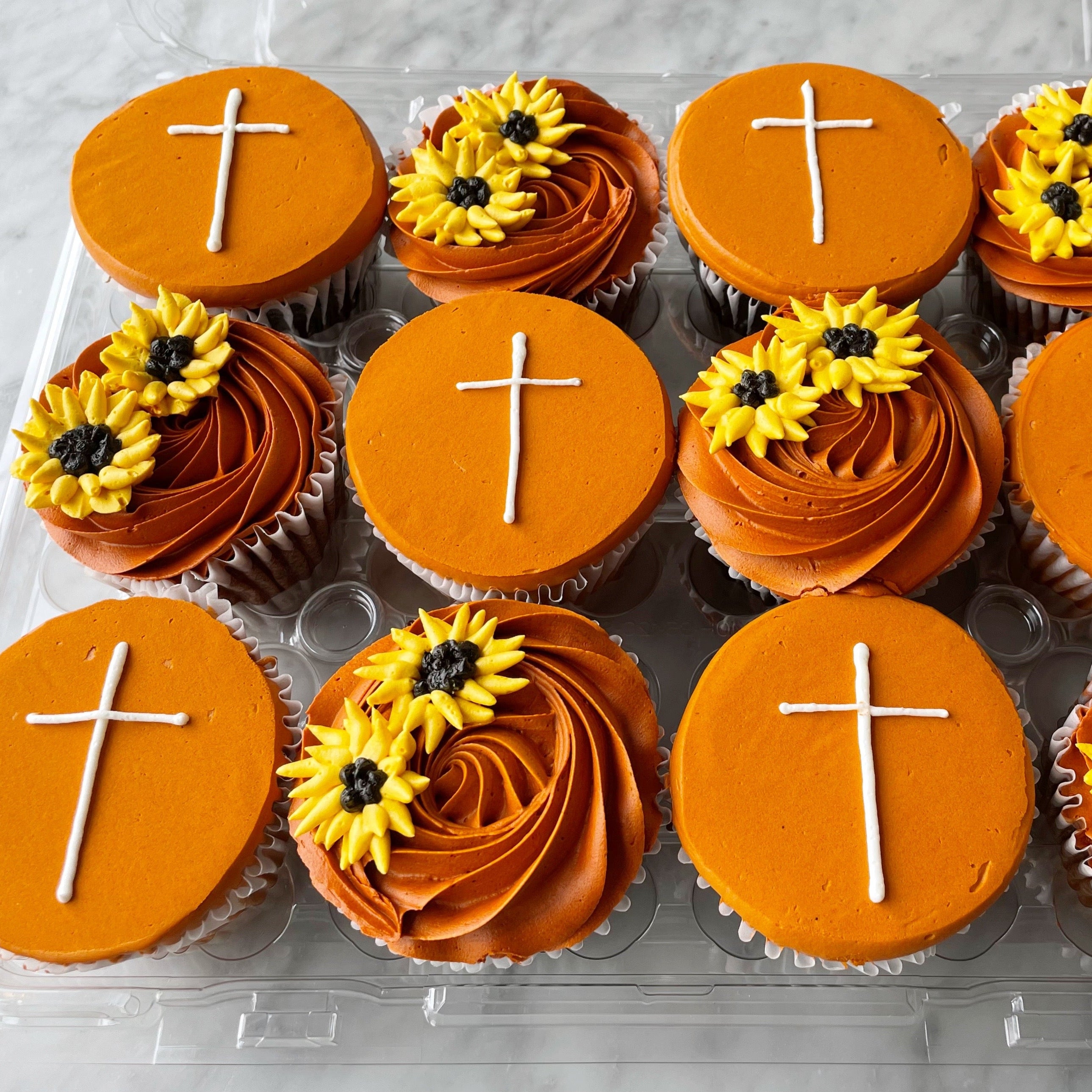 Orange color cupcakes with sunflower and cross theme