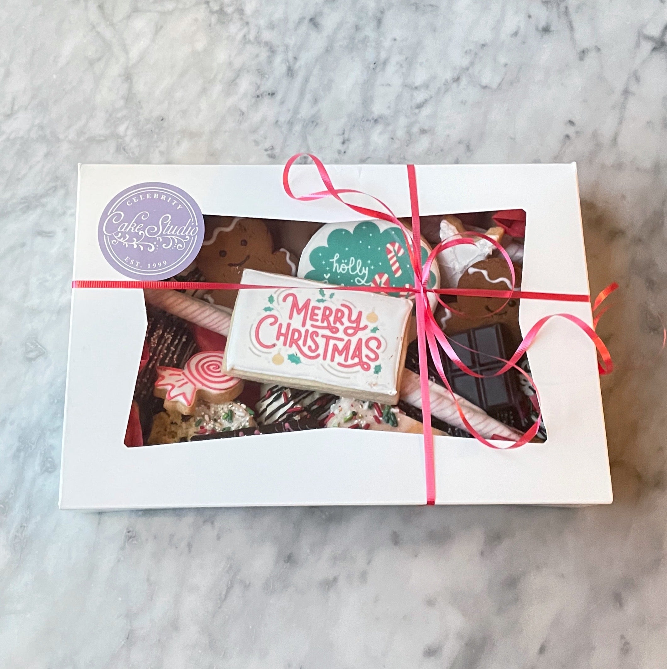 Box of assorted Christmas cookies tied with a pink ribbon