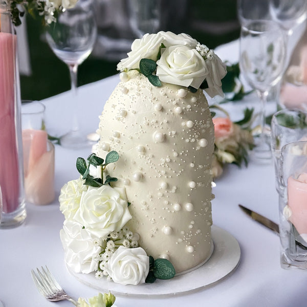White floral wedding cake decorated with small white flowers