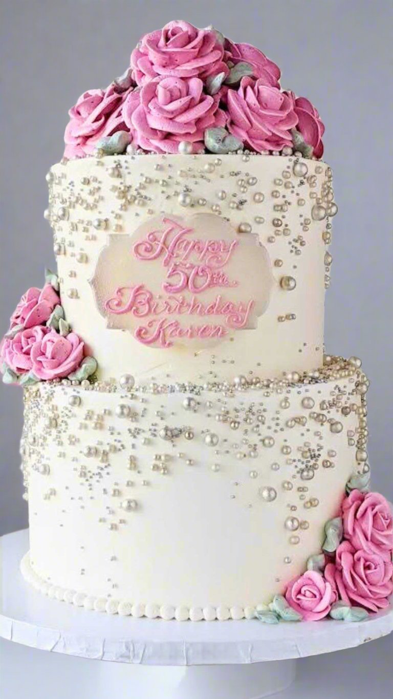 Pink floral tiered cake Two-tier cake with ornate pink flowers and pearl-like piping