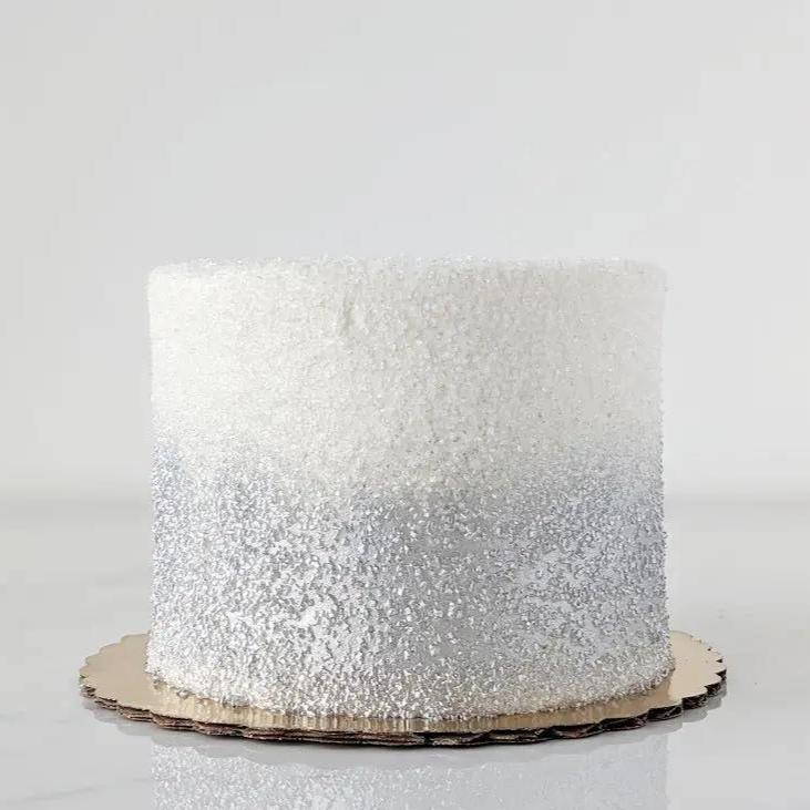 A simple, single-tiered cake with a silver and white ombre frosting design.