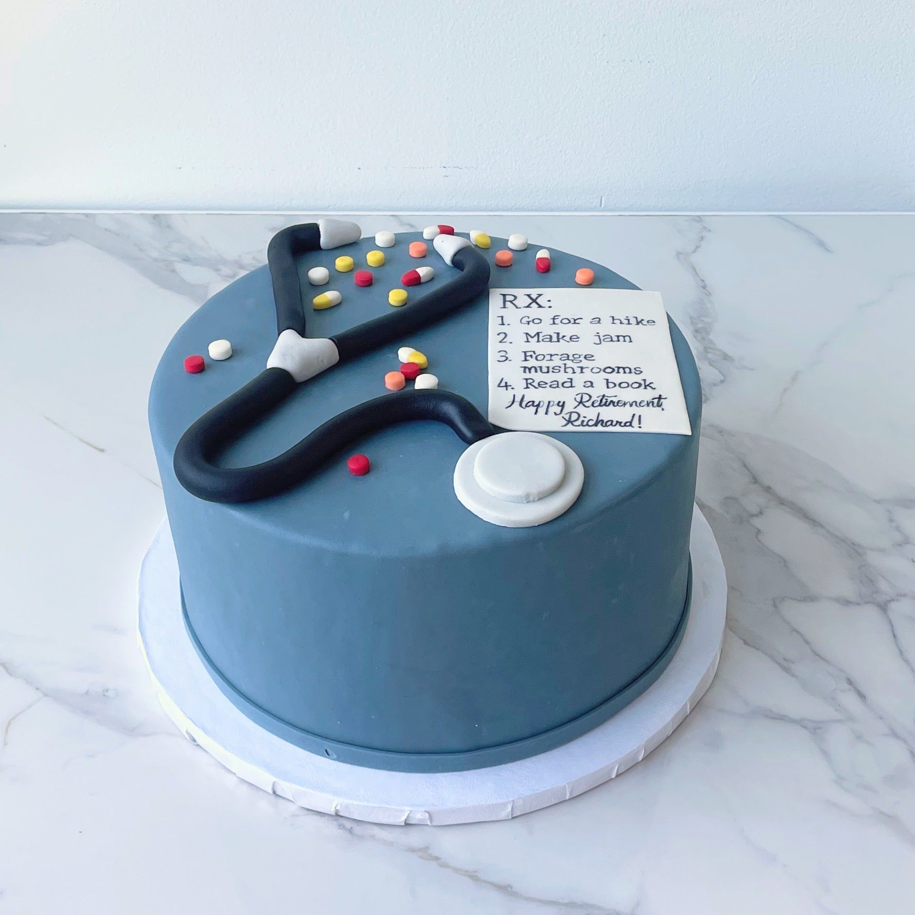 Blue cake with a stethoscope and medical-themed decorations 