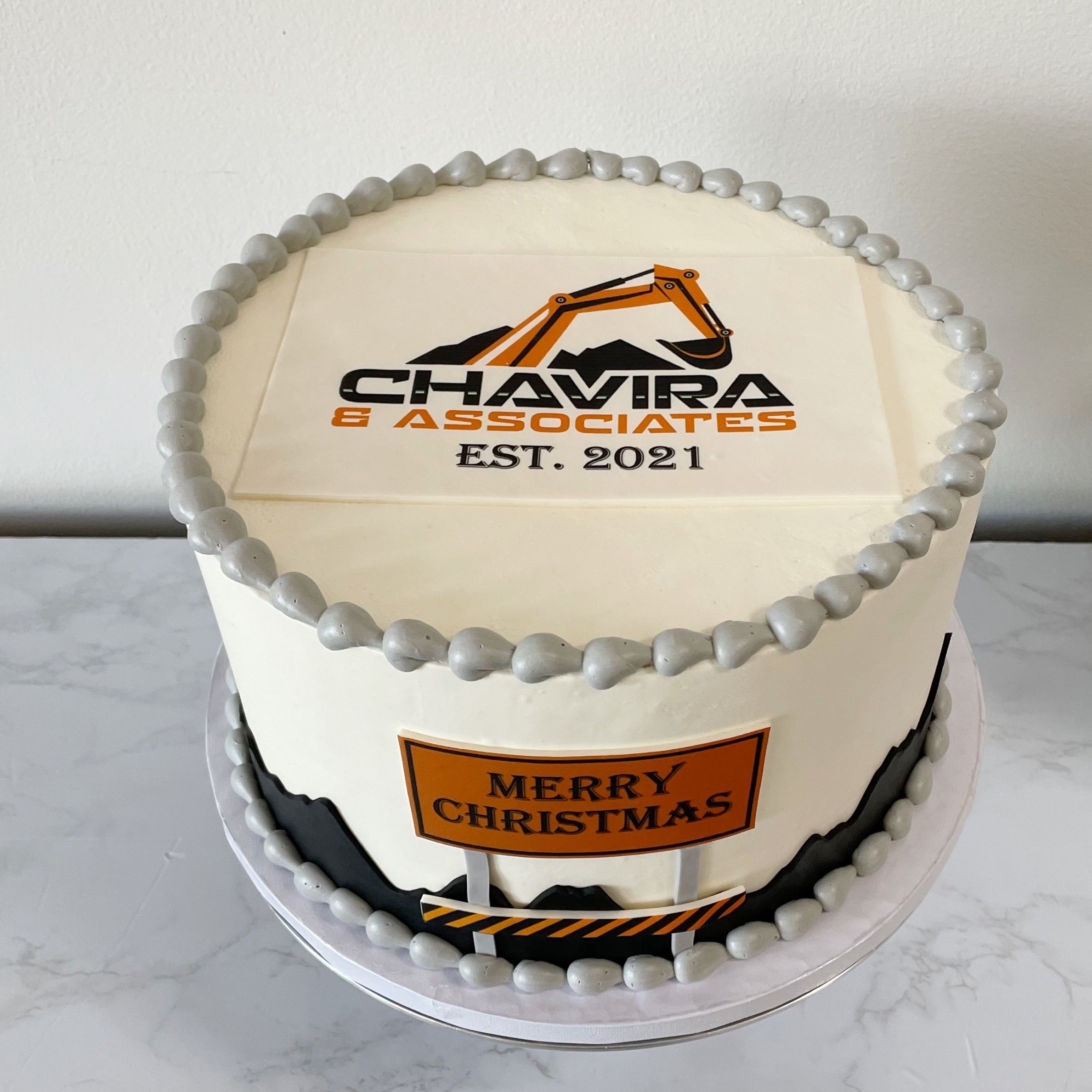 Decorative cake with 'Chavira & Associates' logo and 'Merry Christmas' text on a white background