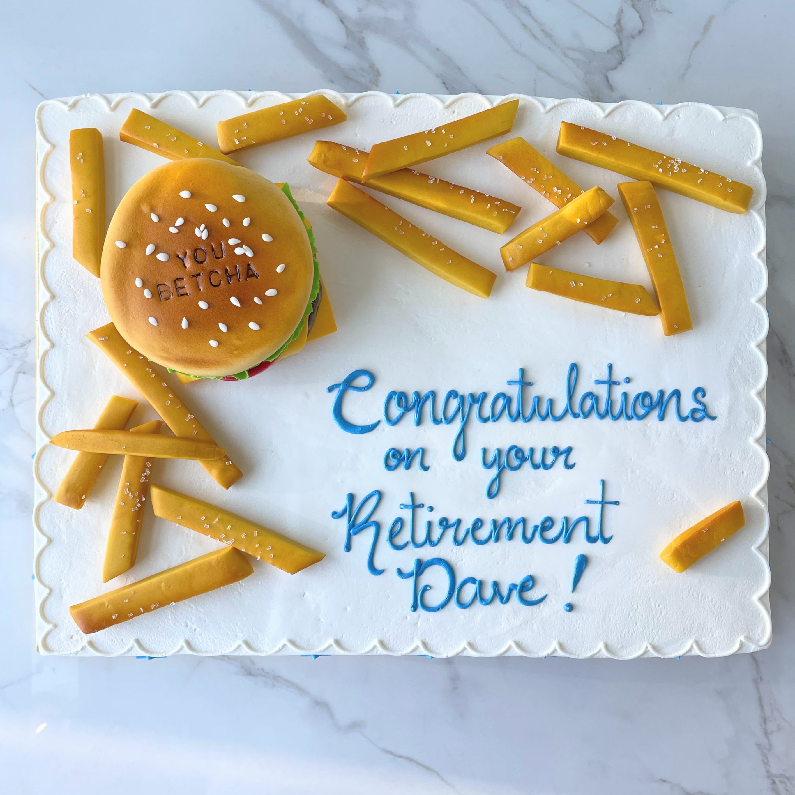 Retirement cake with hamburger and french fries decoration on a marble surface