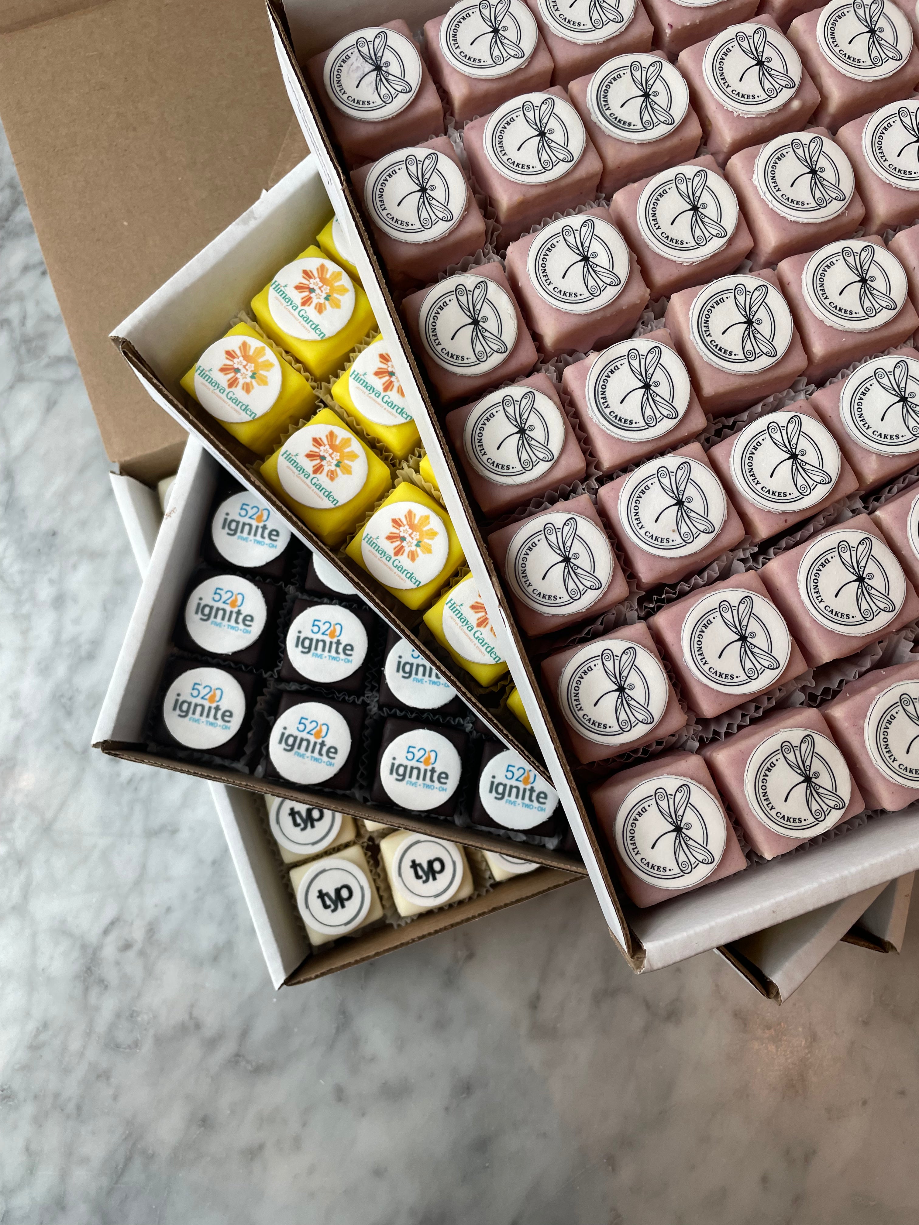 Assorted small boxes with branded labels on a marble surface
