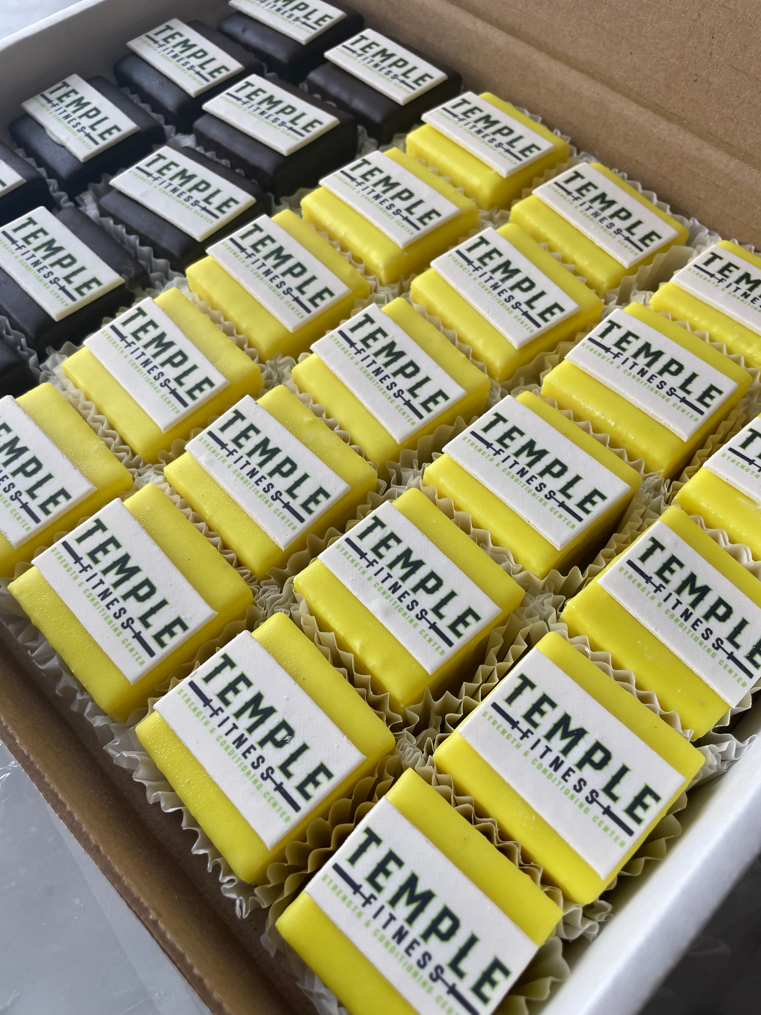 Box of Temple Fitness protein bars in yellow and black packaging.